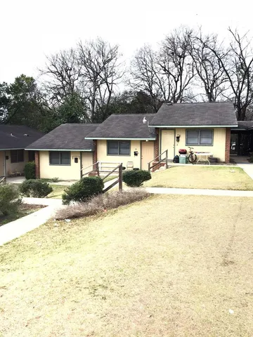a front view of a residential houses with yard and trees