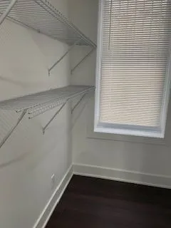 a view of a small space with wooden floor and a window