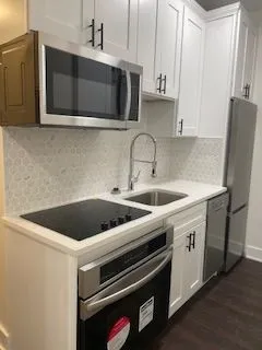 a kitchen with stainless steel appliances a stove microwave and sink