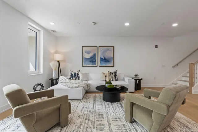 a living room with furniture a rug and white walls