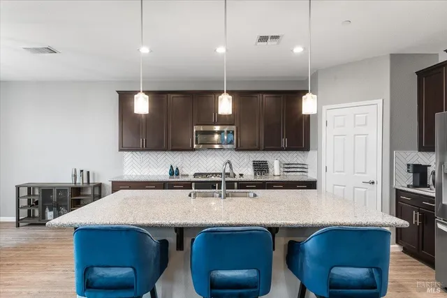 a kitchen with a sink a counter space appliances and cabinets