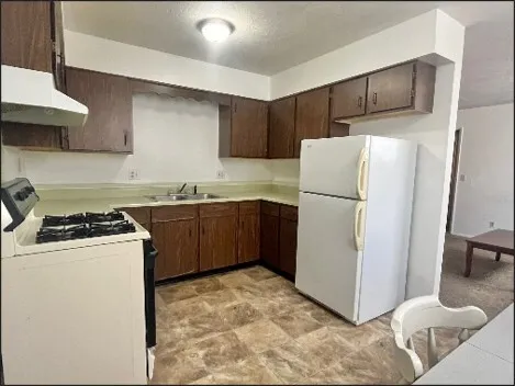 a kitchen with a stove a refrigerator and a sink