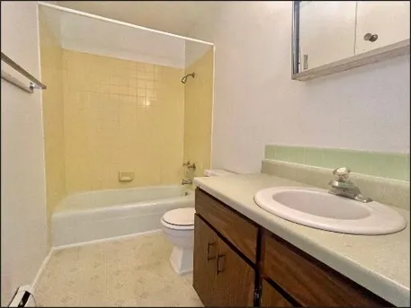 a bathroom with a granite countertop sink a toilet a mirror and shower
