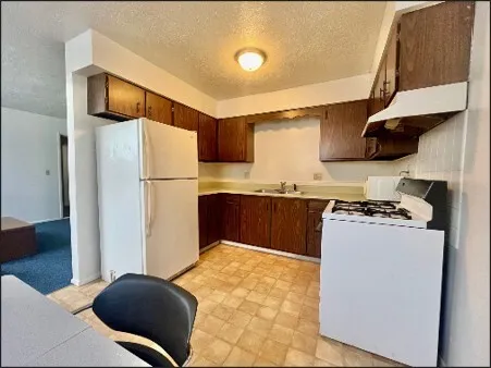 a kitchen with stainless steel appliances a refrigerator and a stove top oven