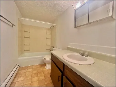 a bathroom with a granite countertop sink toilet a mirror and shower
