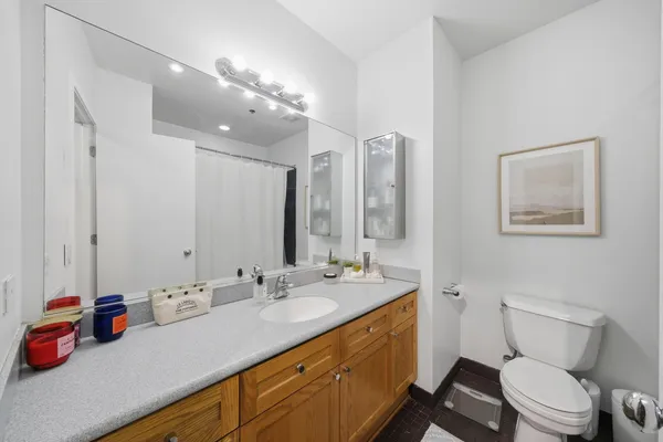a bathroom with a sink vanity mirror and toilet