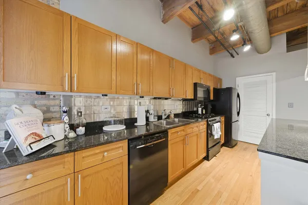 a kitchen with stainless steel appliances granite countertop a sink a stove and cabinets