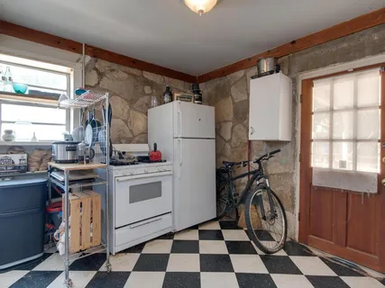 a kitchen with a refrigerator a stove top oven and a window