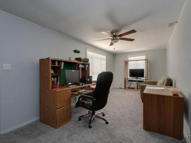 a view of a workspace with furniture and a window