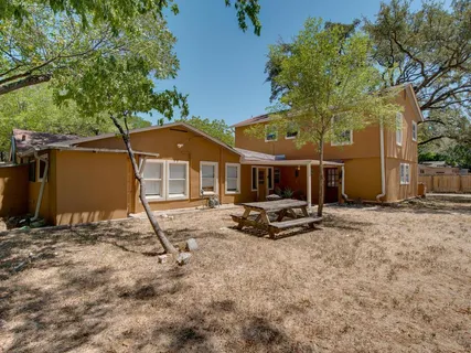 a view of a house with backyard and sitting area