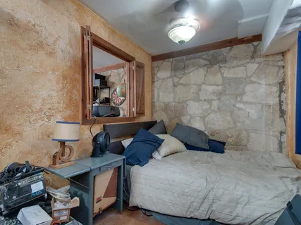 a bedroom with a bed and a dresser with mirror