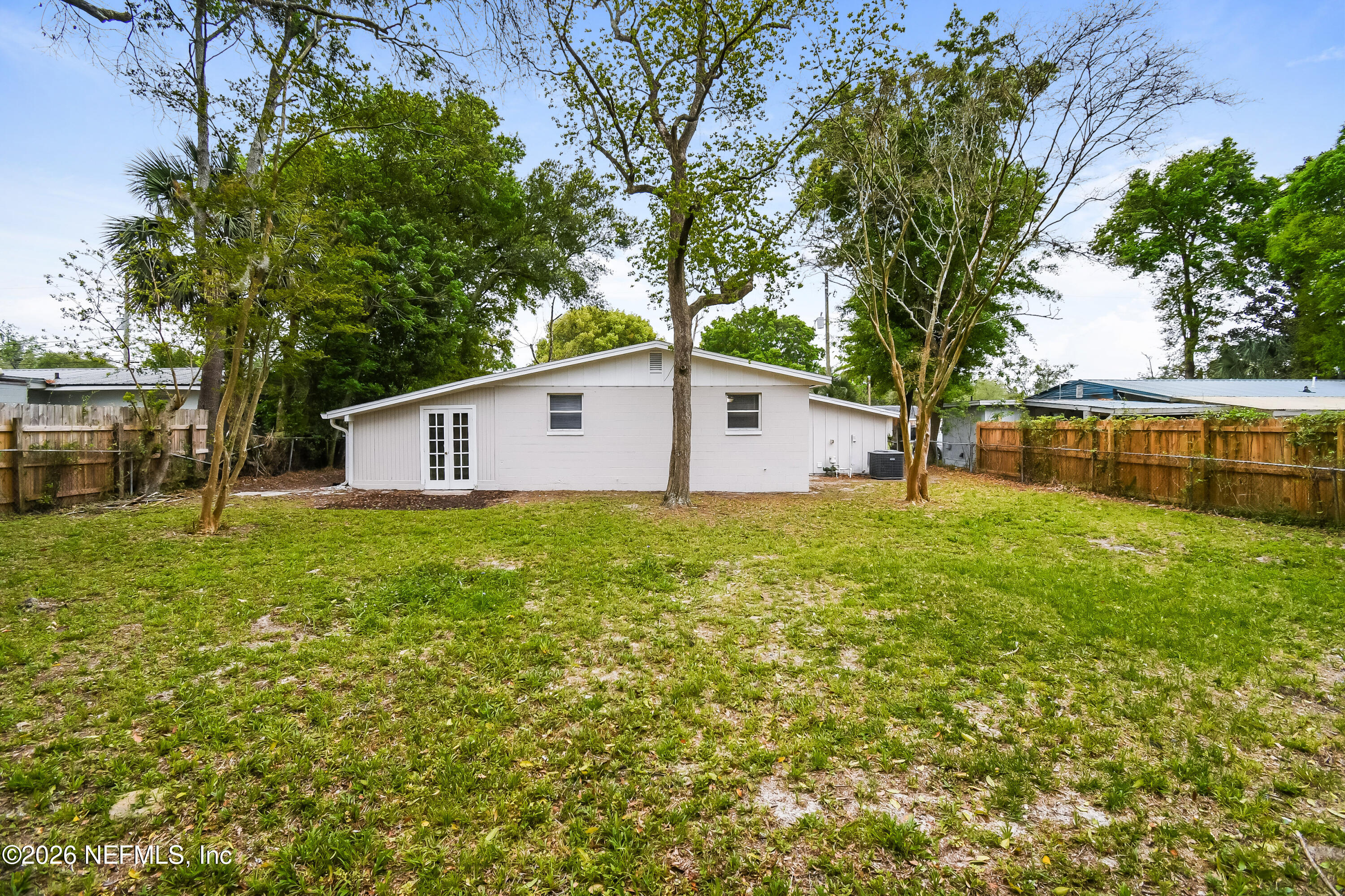 7227 Stonehurst Road North Jacksonville, FL 32277 - Photo 15 of 16 a view of a backyard with large trees and wooden fence