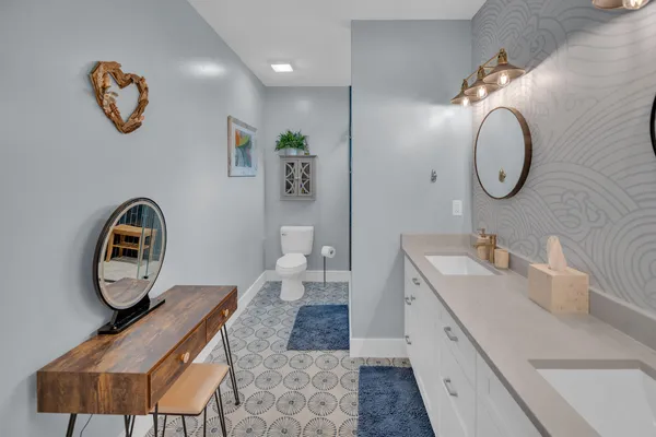 a bathroom with a granite countertop sink a toilet and shower