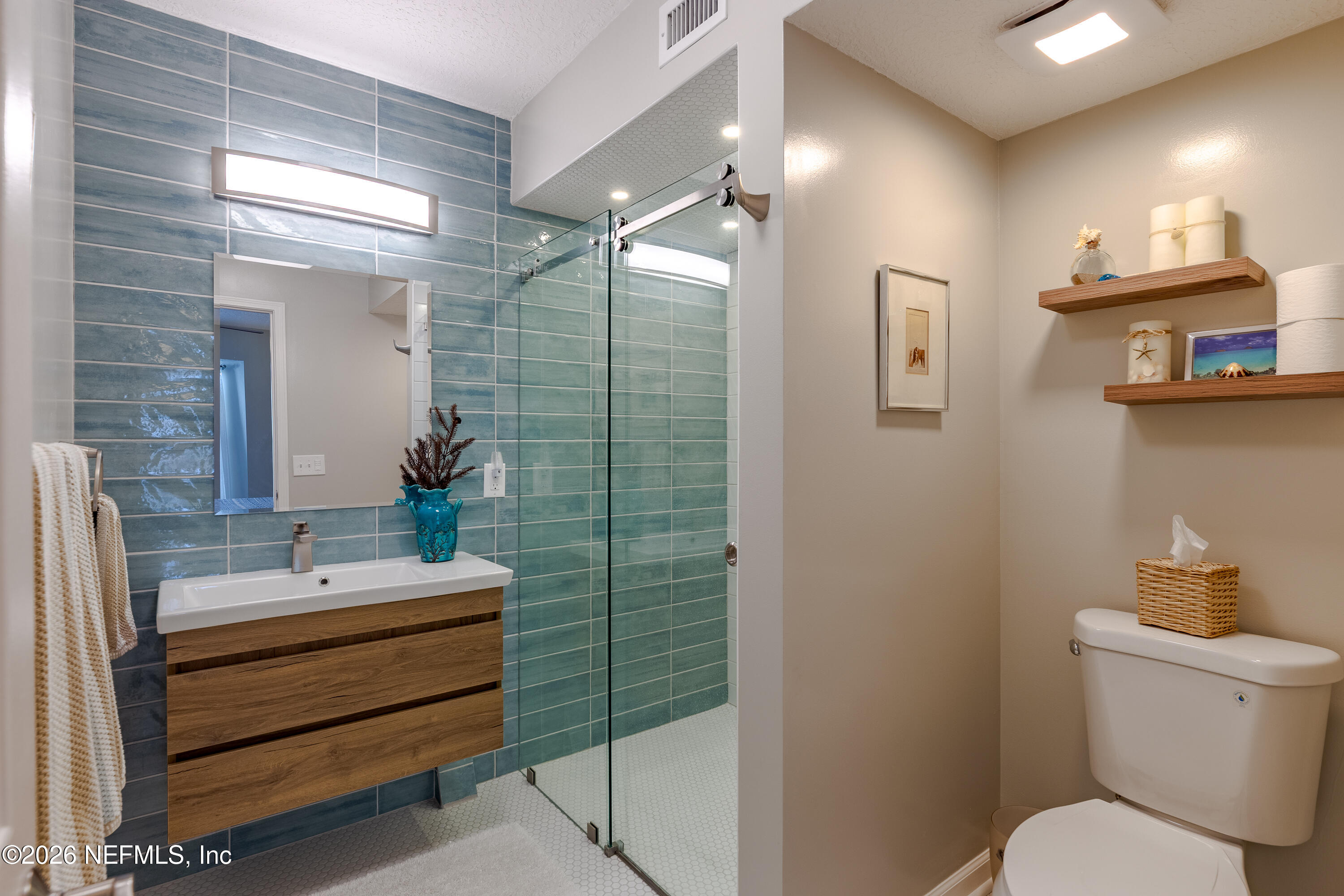 3327 Lighthouse Point Lane Jacksonville, FL 32250 - Photo 14 of 56 a bathroom with a sink mirror and toilet
