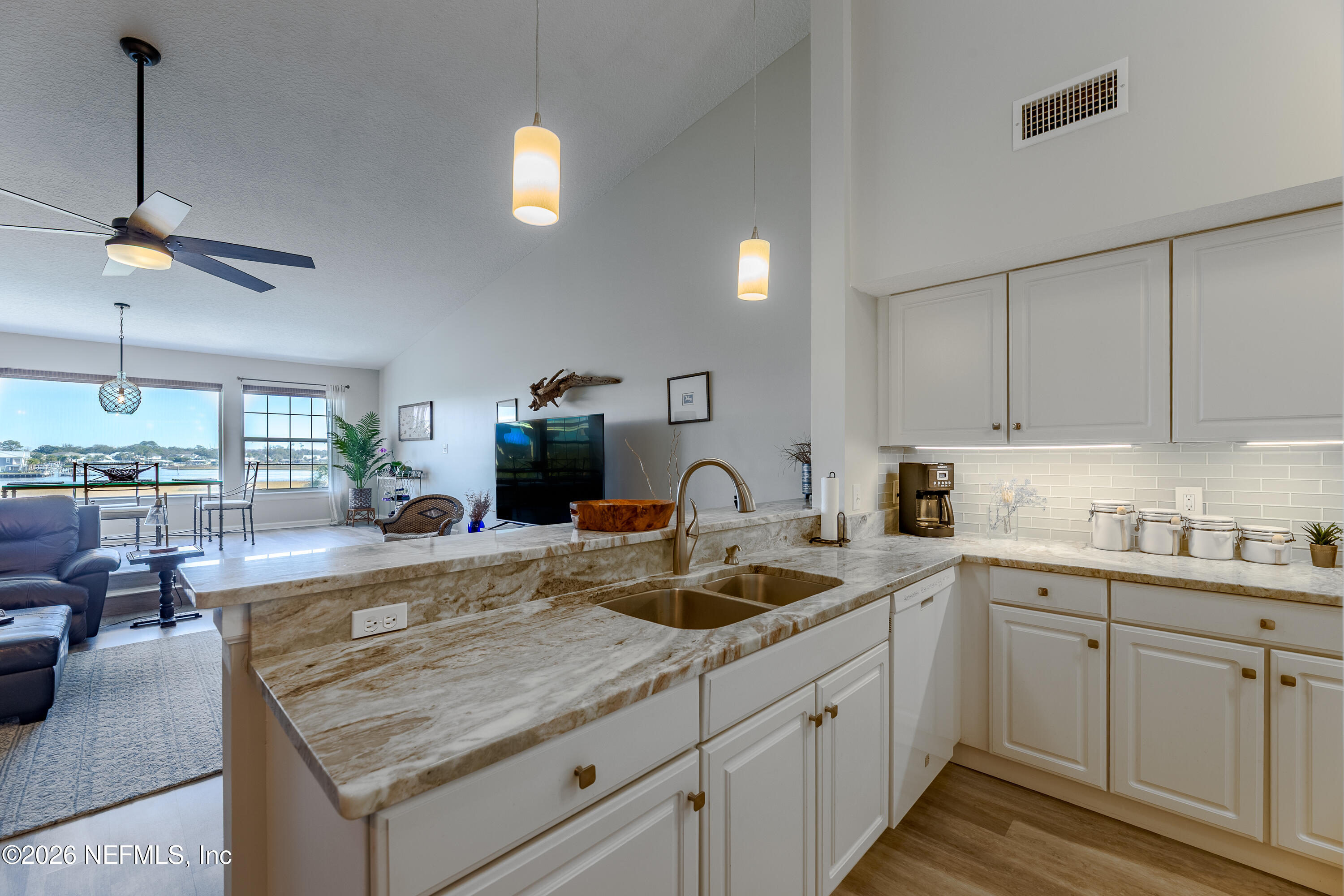 3327 Lighthouse Point Lane Jacksonville, FL 32250 - Photo 26 of 56 a kitchen with kitchen island granite countertop a sink a counter space appliances and cabinets