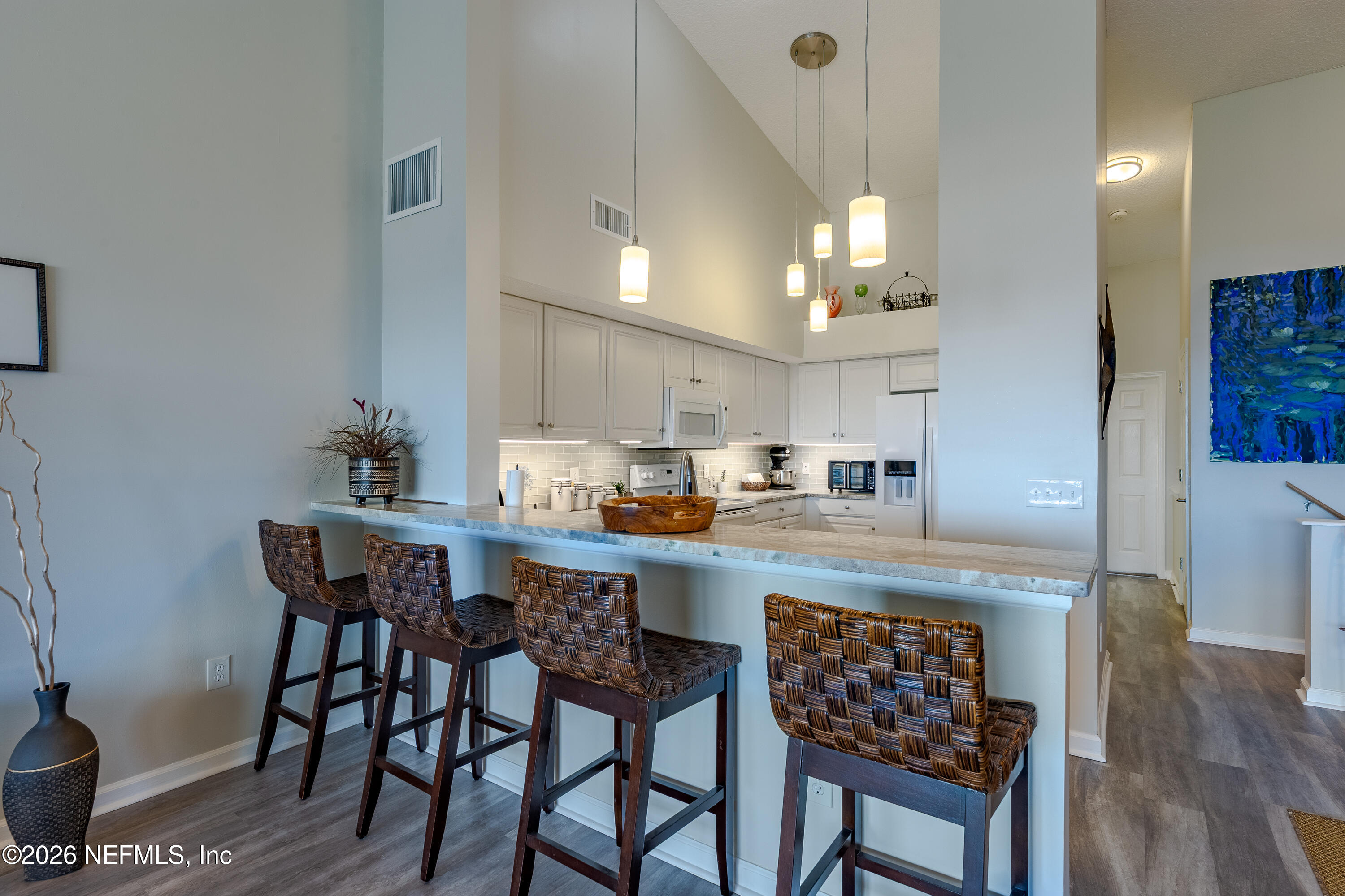 3327 Lighthouse Point Lane Jacksonville, FL 32250 - Photo 28 of 56 a kitchen with kitchen island a dining table chairs and white cabinets