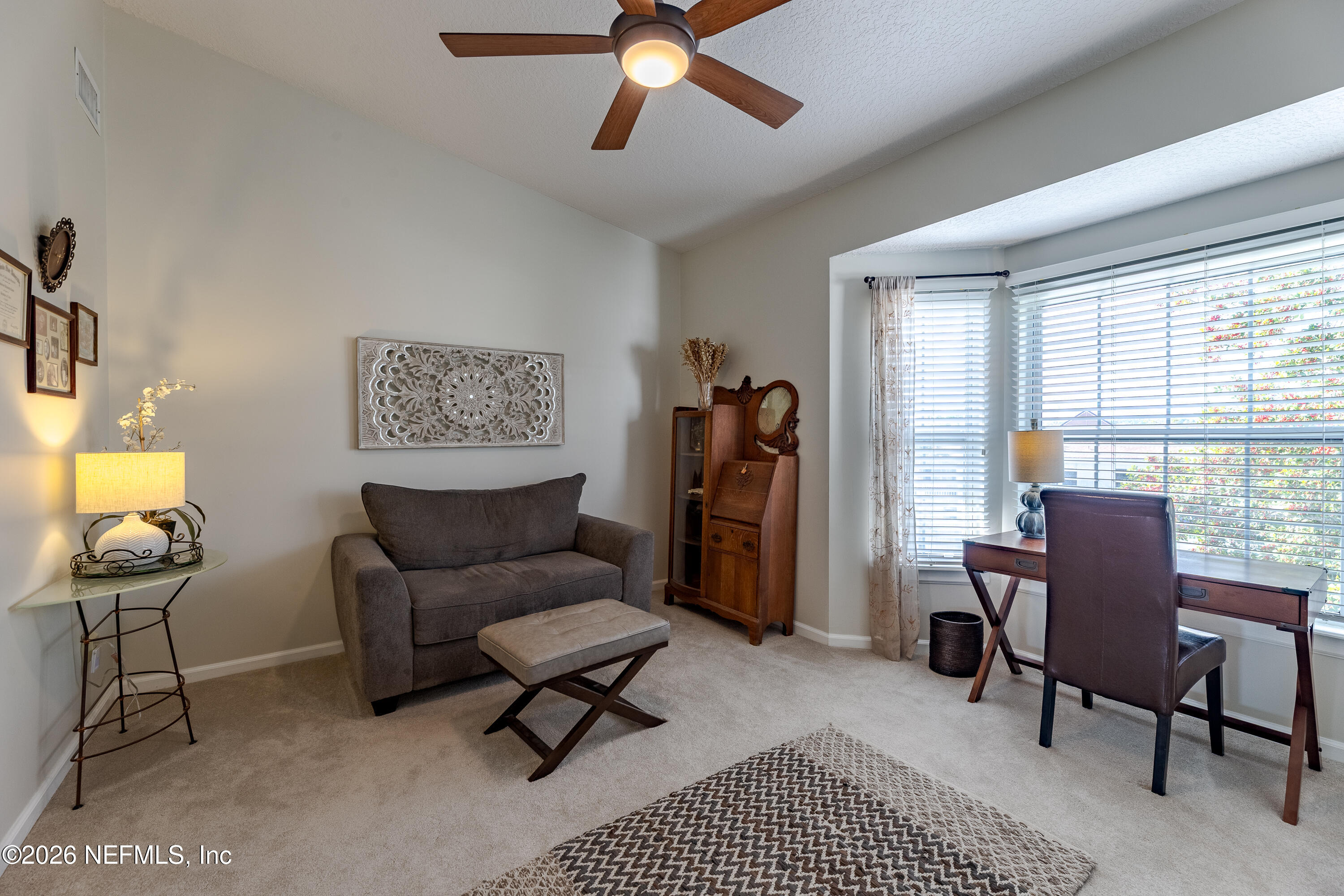3327 Lighthouse Point Lane Jacksonville, FL 32250 - Photo 36 of 56 a living room with furniture a desk and chair with a bookshelf