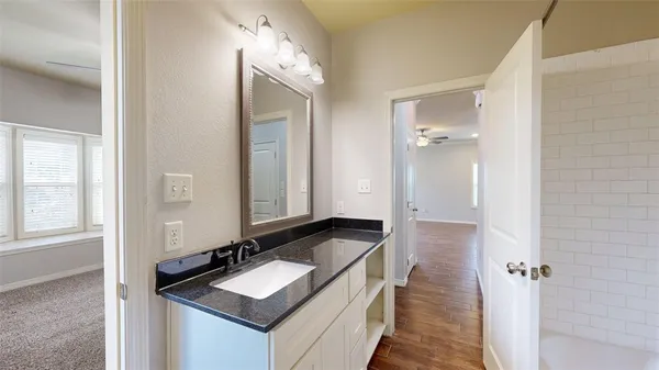 a bathroom with a granite countertop sink and a mirror