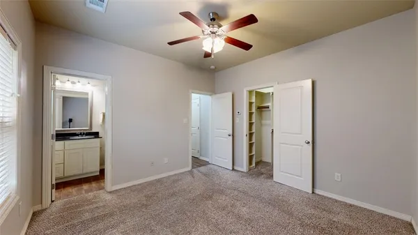 a view of a livingroom with a chandelier fan and windows