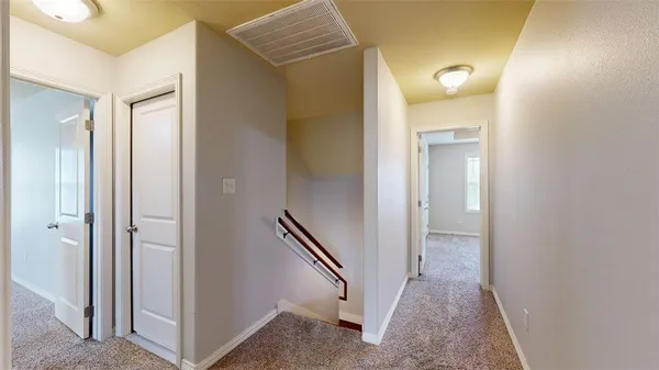 a view of a hallway with closet and wooden floor