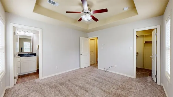 an empty room with closet and a ceiling fan