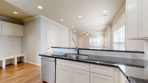 a kitchen with stainless steel appliances granite countertop a sink and a wooden floors