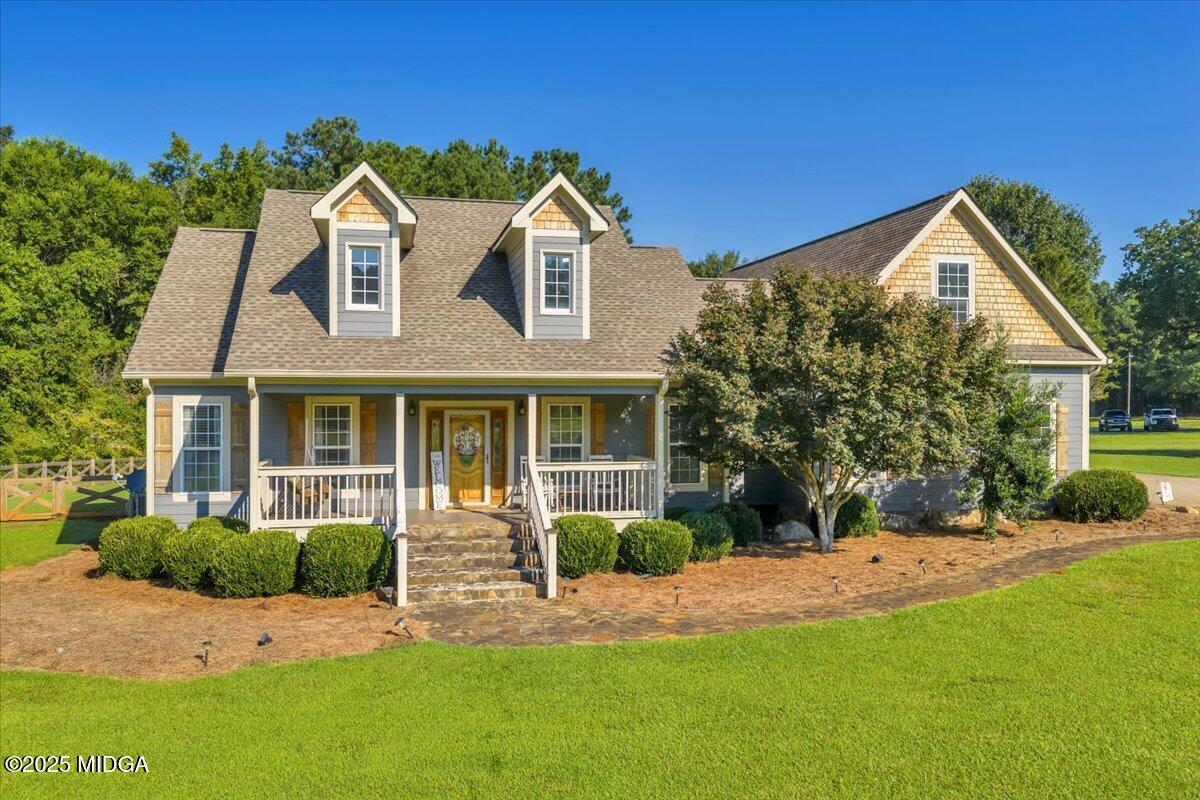 a front view of a house with a yard and potted plants