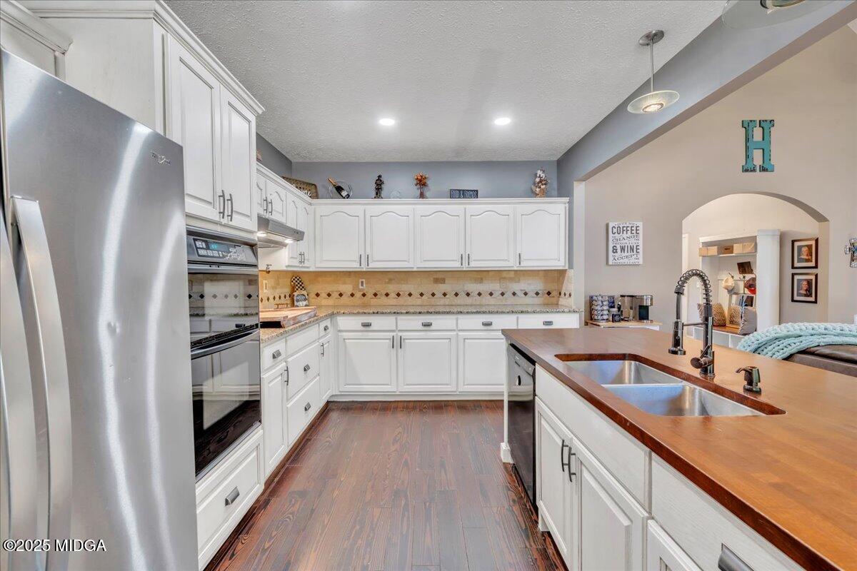 16 Little Collier Road Forsyth, GA 31029 - Photo 14 of 55 a kitchen with white cabinets and stainless steel appliances