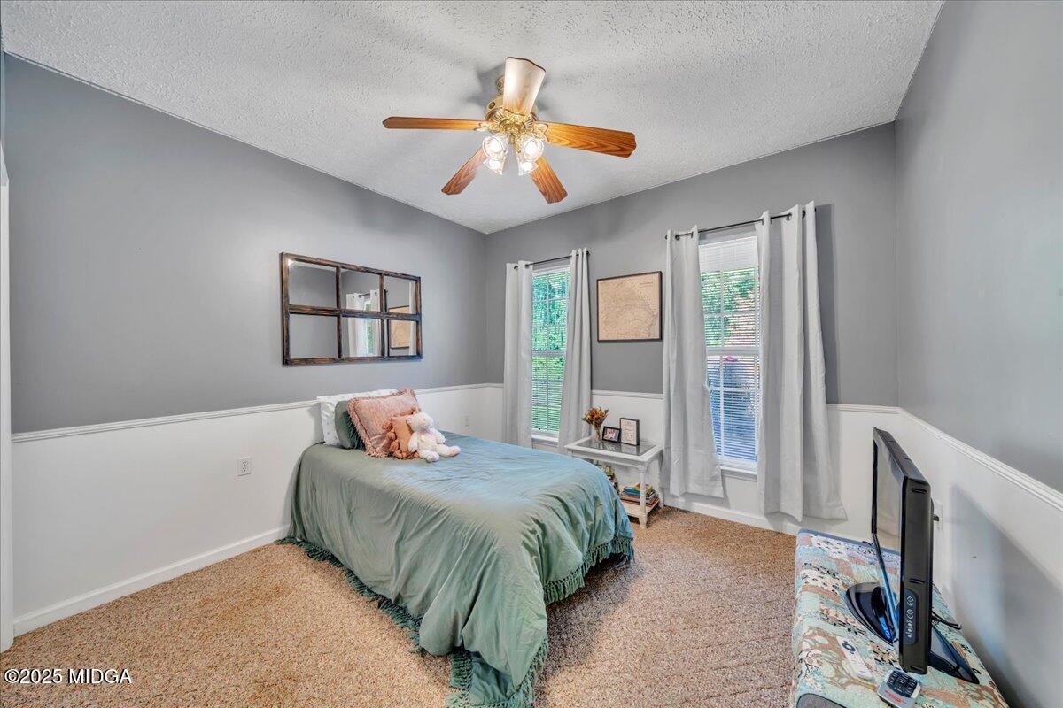 16 Little Collier Road Forsyth, GA 31029 - Photo 34 of 55 a bedroom with a large bed and a chandelier