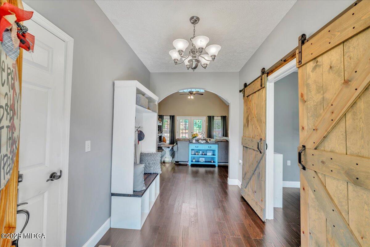16 Little Collier Road Forsyth, GA 31029 - Photo 5 of 55 a view of a hallway with wooden floor and chandelier