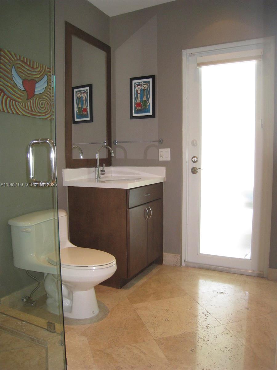7440 Southwest 126th Street Pinecrest, FL 33156 - Photo 16 of 22 a bathroom with a toilet sink and mirror