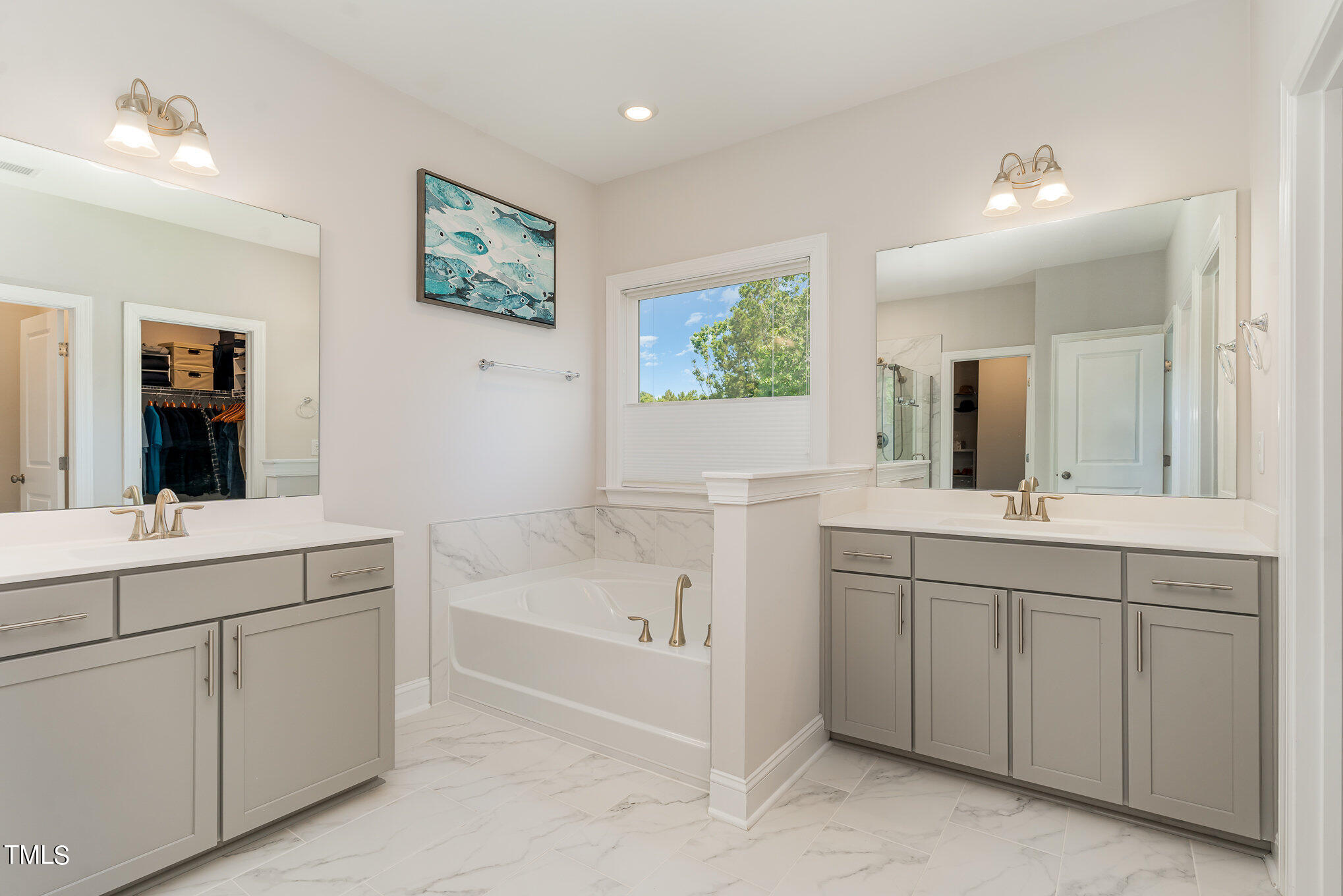 171 High Woods Ridge Pittsboro, NC 27312 - Photo 19 of 51 a bathroom with a double vanity sink a large mirror a bathtub and window