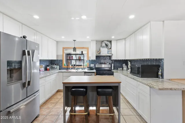 a kitchen with refrigerator and cabinets