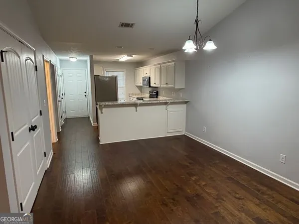 a kitchen with a refrigerator a sink and a wooden floor