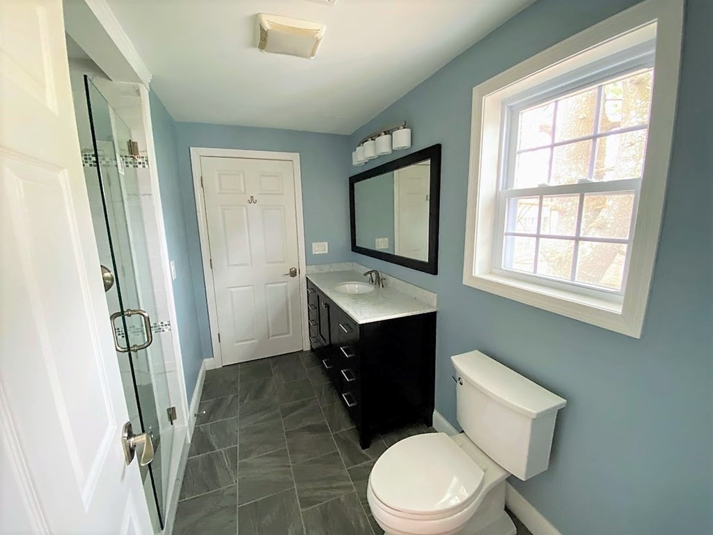 390 Marrett Road Lexington, MA 02421 - Photo 9 of 11 a bathroom with a toilet sink and mirror