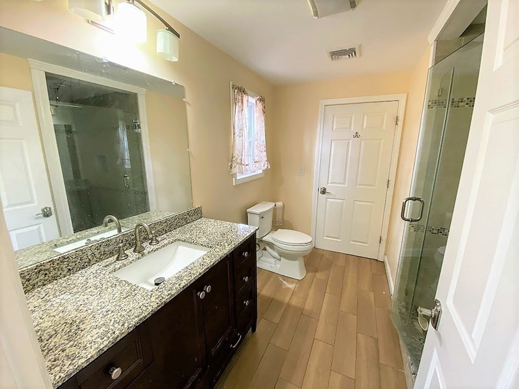 390 Marrett Road Lexington, MA 02421 - Photo 10 of 11 a spacious bathroom with a granite countertop sink and a mirror