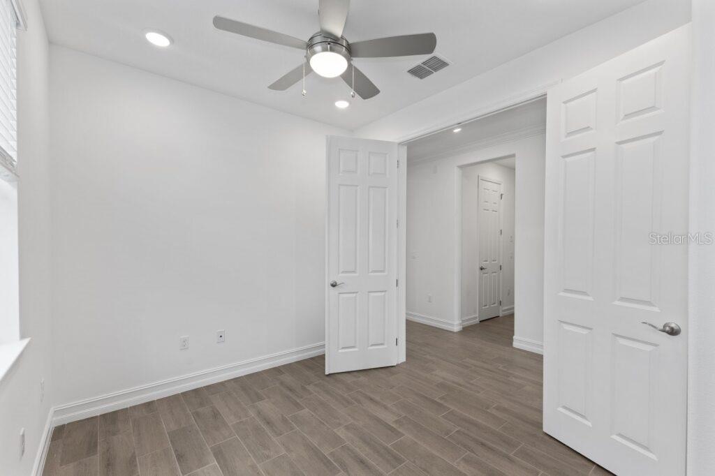 3223 Northwest 52nd Avenue Road Ocala, FL 34482 - Photo 15 of 25 an empty room with wooden floor and ceiling fan