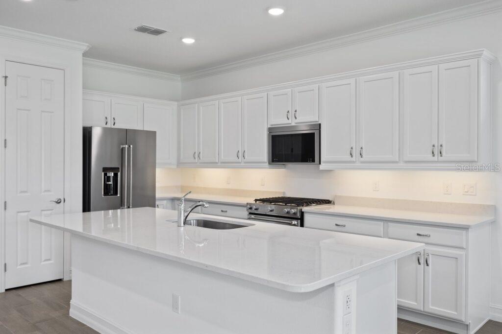 3223 Northwest 52nd Avenue Road Ocala, FL 34482 - Photo 3 of 25 a kitchen with kitchen island a sink a stove and refrigerator