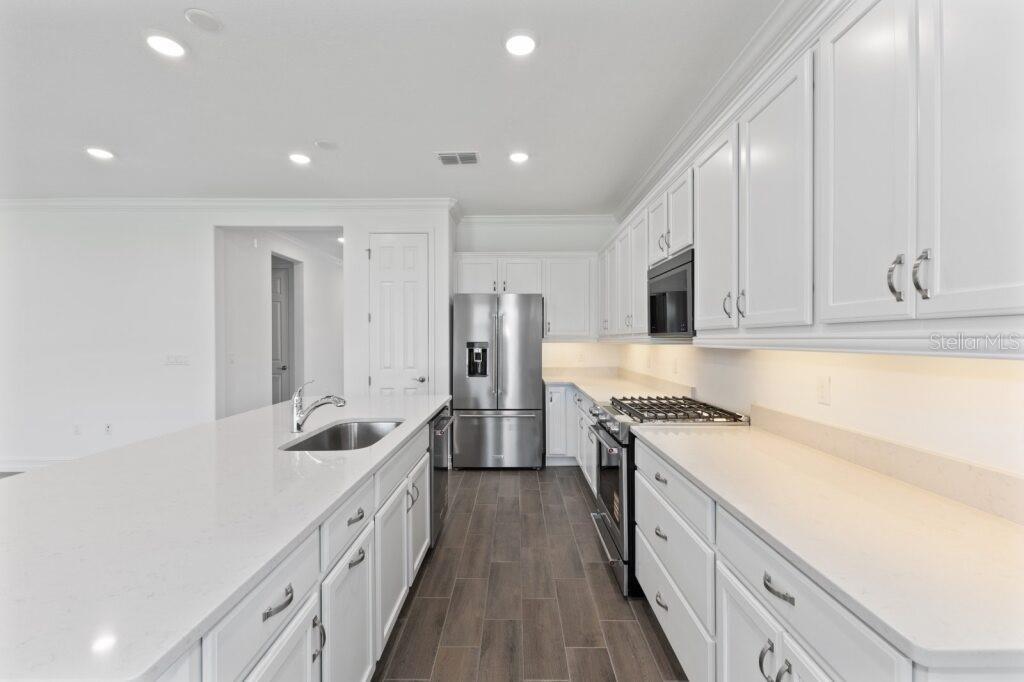3223 Northwest 52nd Avenue Road Ocala, FL 34482 - Photo 5 of 25 a large kitchen with stainless steel appliances granite countertop a lot of counter space and wooden floors