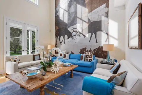 a living room with furniture fireplace and a large window