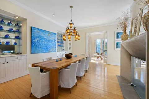 a dining hall with stainless steel appliances granite countertop a sink dishwasher a dining table and chairs with wooden floor