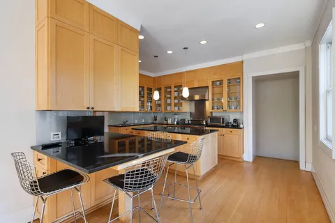 a kitchen with stainless steel appliances granite countertop a stove a sink and a microwave