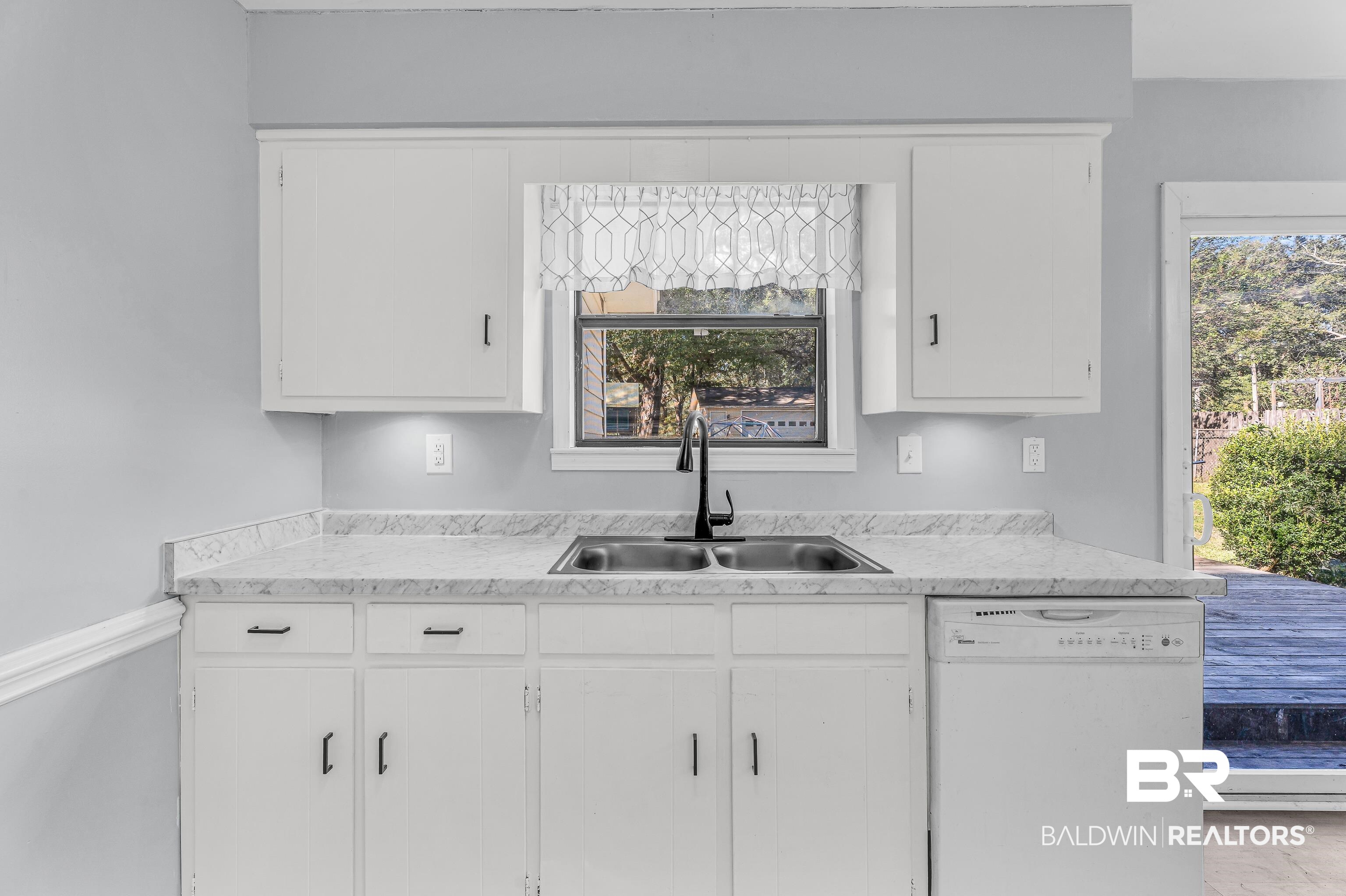6135 Oak Cliff Drive Eight Mile, AL 36613 - Photo 14 of 30 Kitchen with dishwasher, light countertops, and white cabinetry