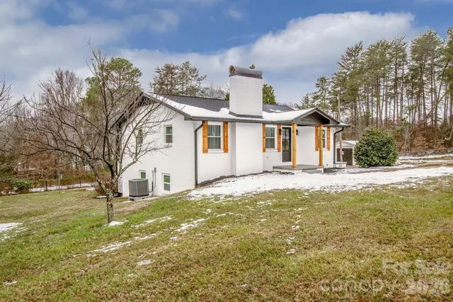 an empty room with wooden floor and large windows