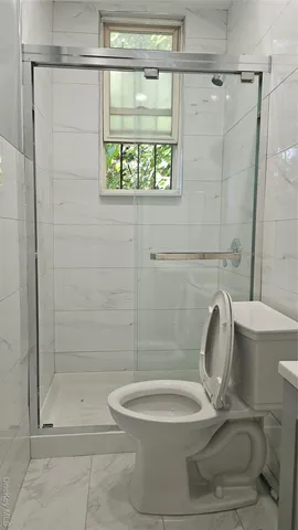 a bathroom with a toilet and a shower