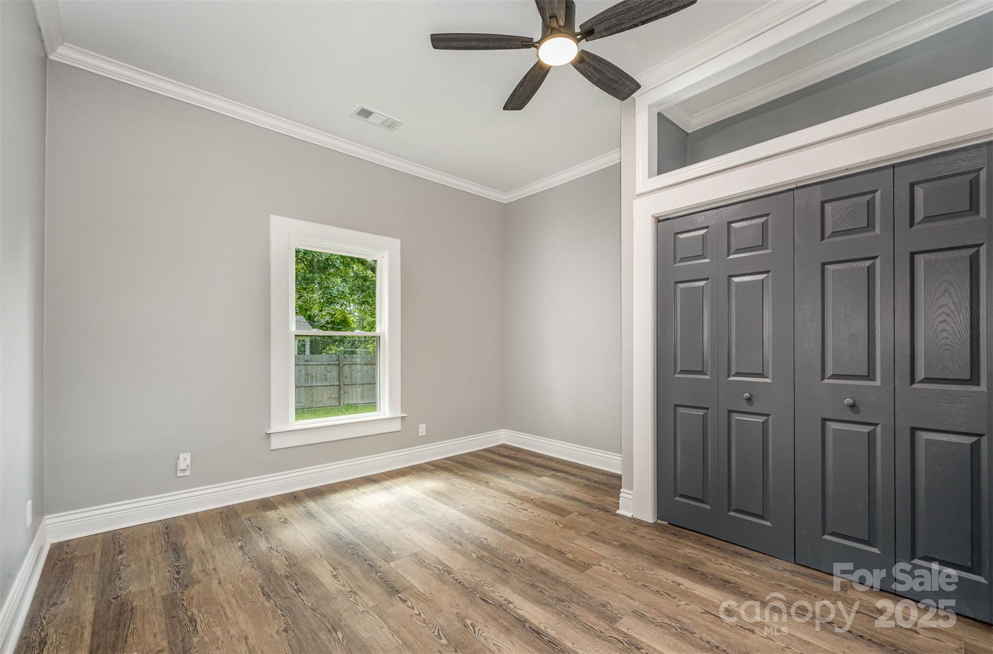 201 Valley Street Stanley, NC 28164 - Photo 12 of 25 an empty room with wooden floor cabinet and windows