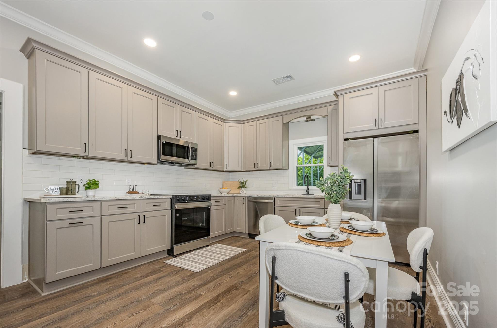 201 Valley Street Stanley, NC 28164 - Photo 3 of 25 a kitchen with granite countertop white cabinets and stainless steel appliances