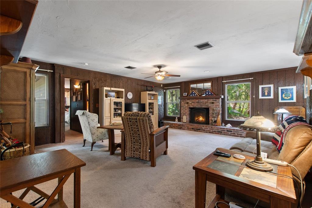 3641 Turtle Mound Road Melbourne, FL 32934 - Photo 24 of 77 a living room with furniture a fireplace and a flat screen tv