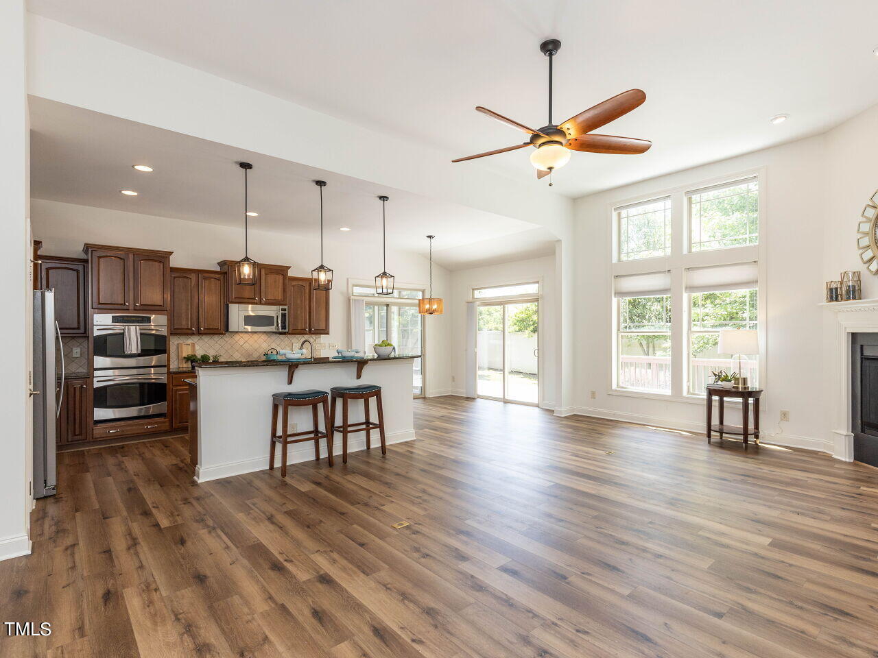 1805 Stonebanks Loop Cary, NC 27518 - Photo 8 of 27 a kitchen with kitchen island white cabinets and stainless steel appliances