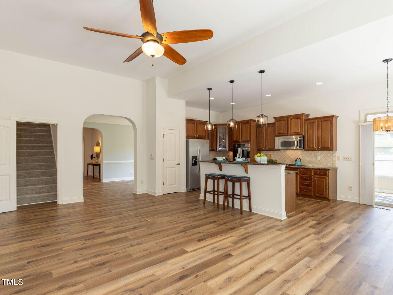 1805 Stonebanks Loop Cary, NC 27518 - Photo 27 of 27 a dining room with kitchen island stainless steel appliances furniture a chandelier and living room view